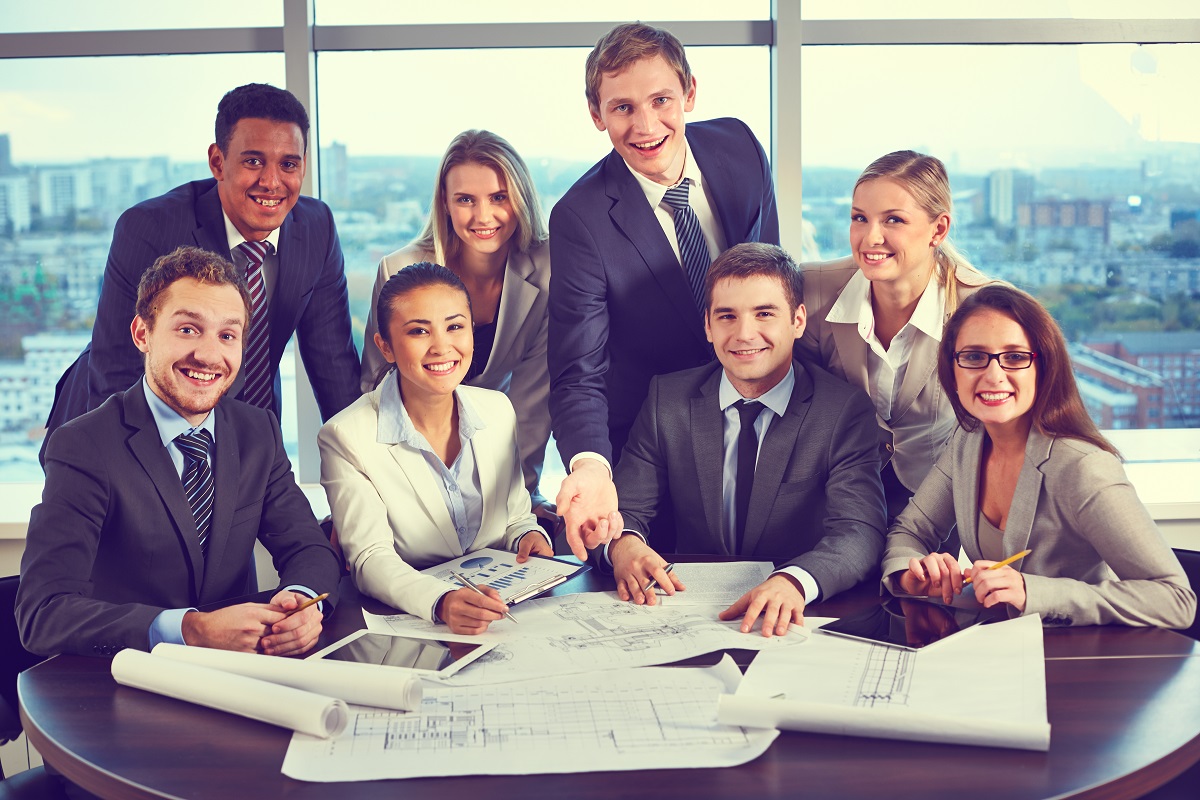 Group of business partners looking at camera with smiles in office